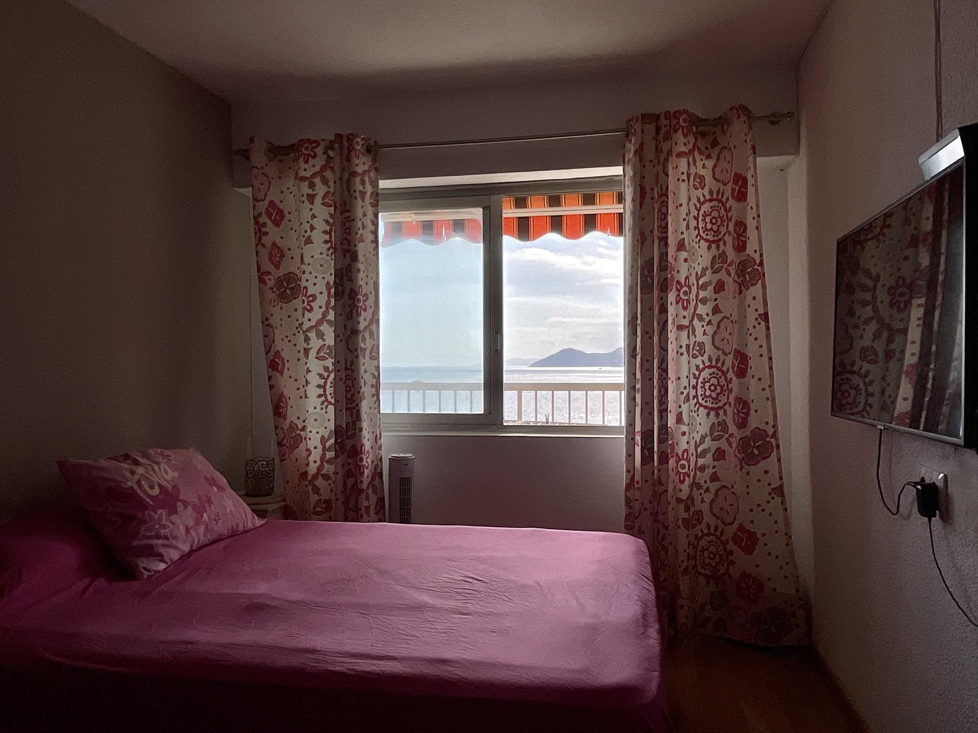 Dormitorio con cama doble y vistas al mar